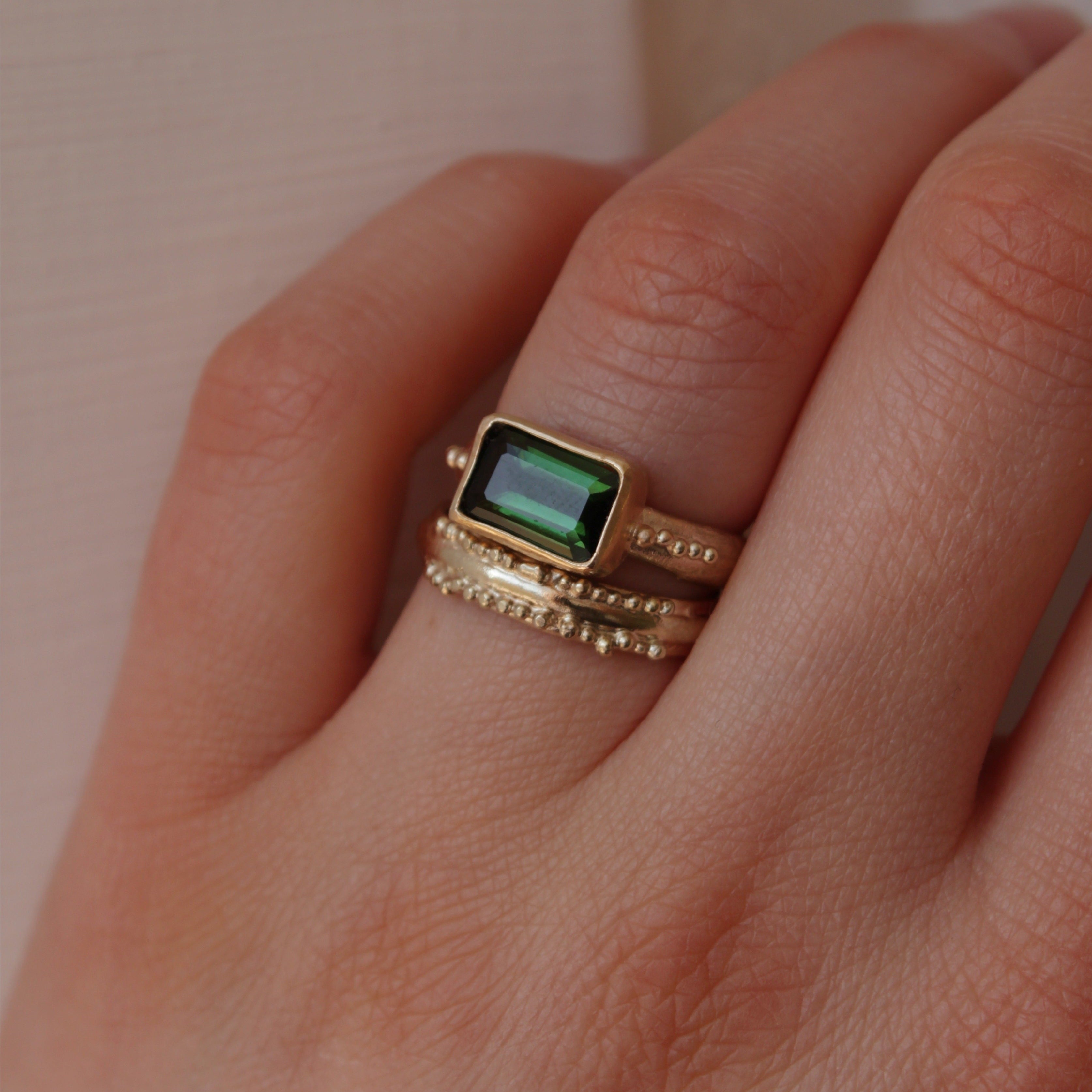 This stunning wedding ring is perfect for the alternative bride looking for an extra special wedding band. Inspired by ancestral metalsmithing techniques, this ring featured delicate granulation details that capture the light beautifully. Worn with the Green Tourmaline engagement ring