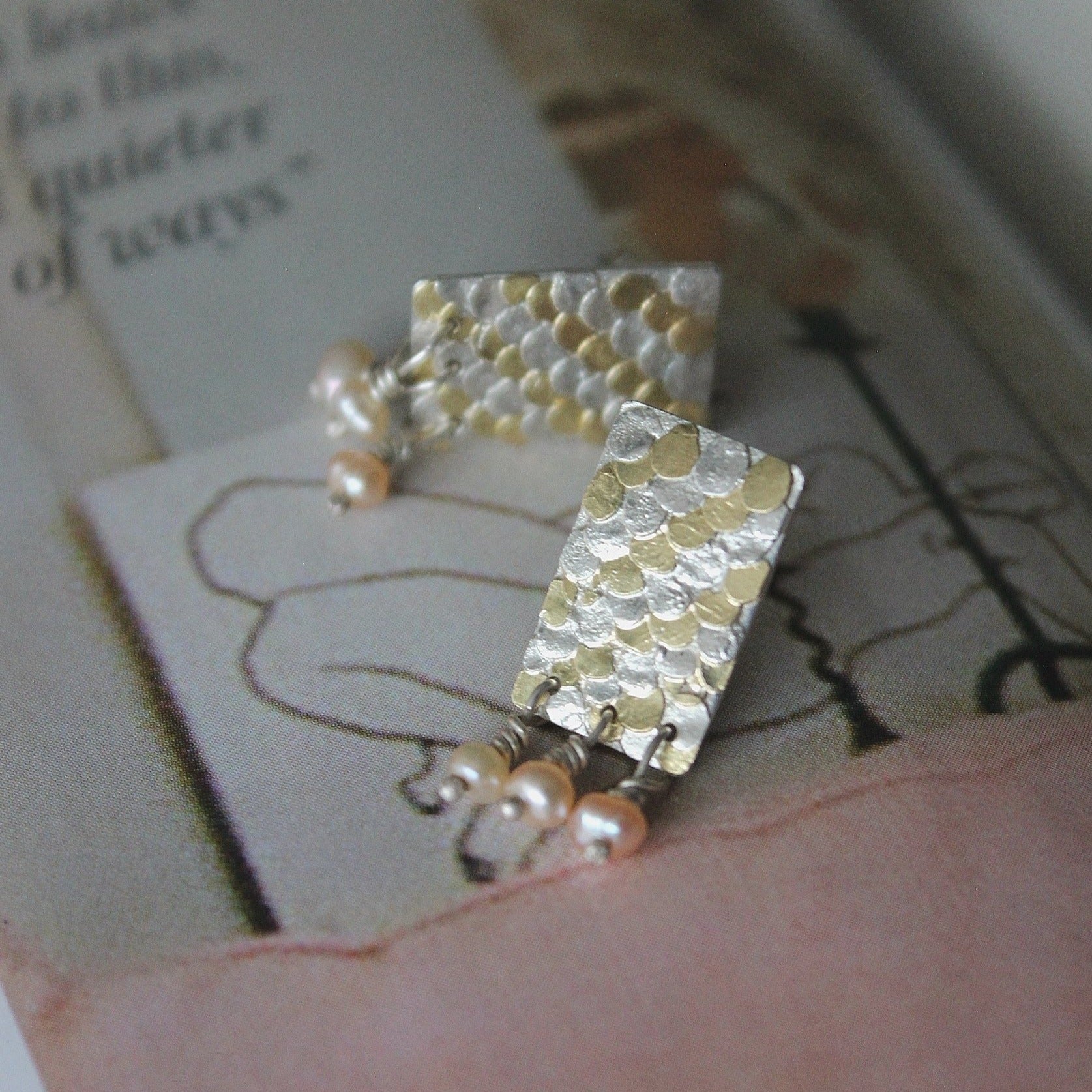 The Siren studs have been mindfully designed by Bournemouth based, Josie Mitchell jewellery, to be lightweight with luxurious, delicate details. Hand forged silver and 18ct gold scales are layered up to create a wonderful mermaid texture along with delicate pink fresh water pearls for a timeless and special pair of earrings.