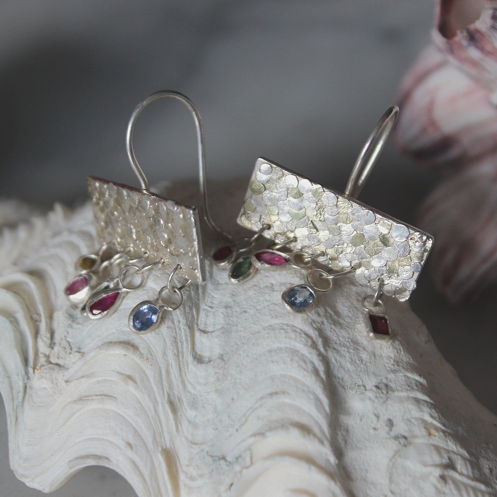 The gorgeous Calypso earrings are one of my favourite creations! They feature 10 brightly coloured natural Sapphires that hang from the bottom of the Siren plates to create a beautiful shimmer and chime. Delicate hand crafted siren details make this pair of earrings entirely unique and magical. Their otherworldly appearance is entirely one-of-a-kind and unique, hand crafted by Josie Mitchell Jewellery in her Bournemouth studio. 