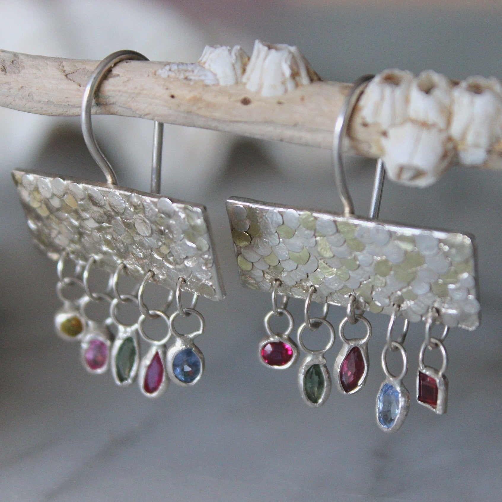 The gorgeous Calypso earrings are one of my favourite creations! They feature 10 brightly coloured natural Sapphires that hang from the bottom of the Siren plates to create a beautiful shimmer and chime. Delicate hand crafted siren details make this pair of earrings entirely unique and magical. Their otherworldly appearance is entirely one-of-a-kind and unique, hand crafted by Josie Mitchell Jewellery in her Bournemouth studio. 