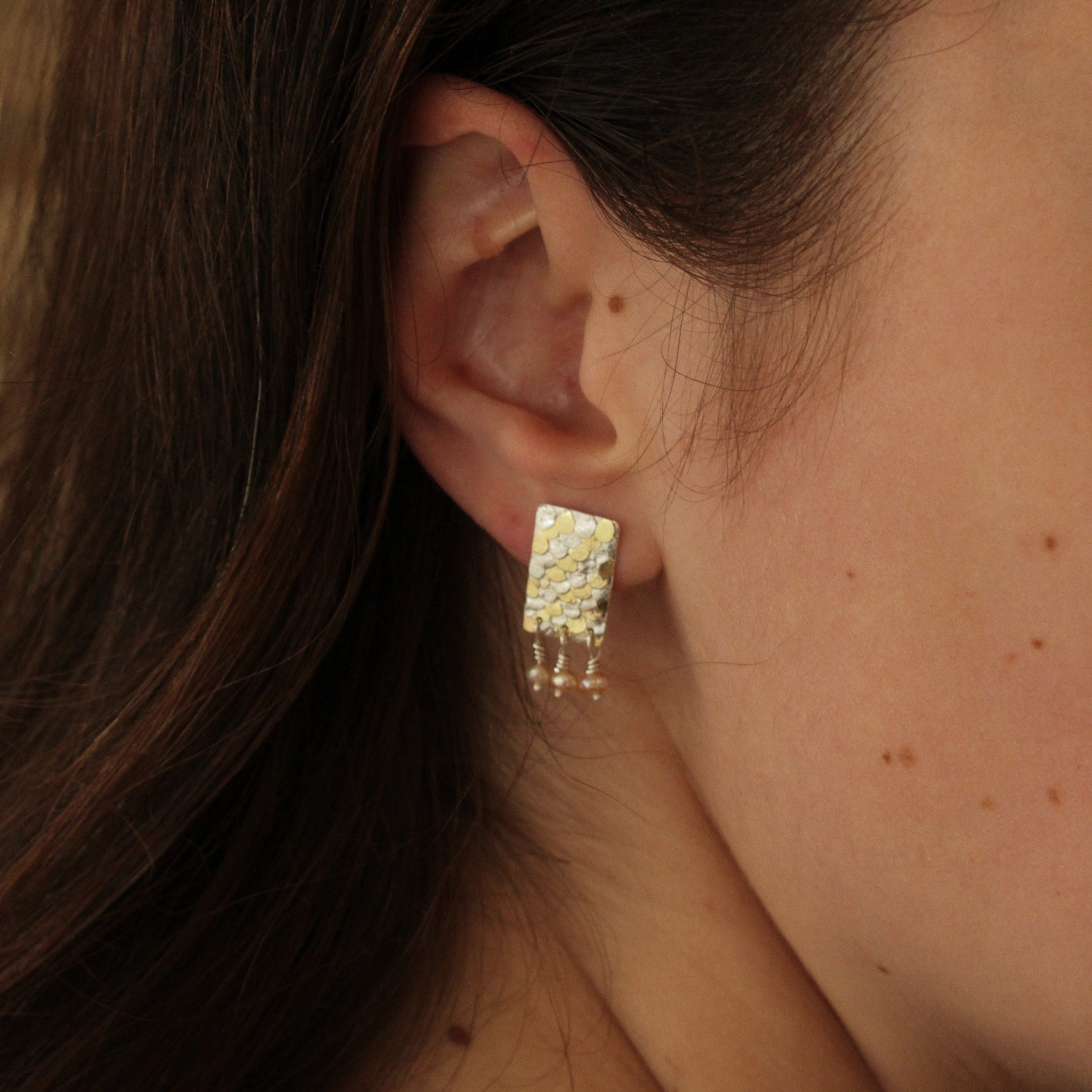 The Siren studs have been mindfully designed by Bournemouth based, Josie Mitchell jewellery, to be lightweight with luxurious, delicate details. Hand forged silver and 18ct gold scales are layered up to create a wonderful mermaid texture along with delicate pink fresh water pearls for a timeless and special pair of earrings.