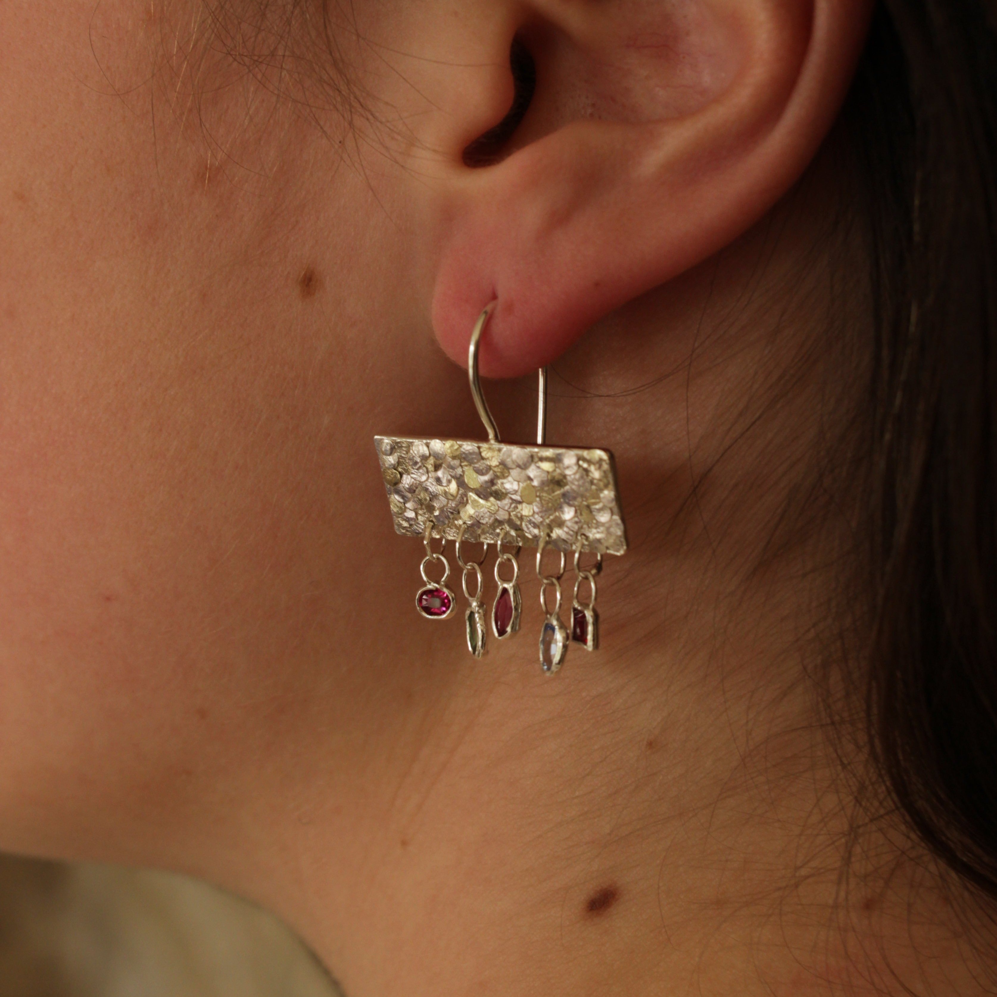 The gorgeous Calypso earrings are one of my favourite creations! They feature 10 brightly coloured natural Sapphires that hang from the bottom of the Siren plates to create a beautiful shimmer and chime. Delicate hand crafted siren details make this pair of earrings entirely unique and magical. Their otherworldly appearance is entirely one-of-a-kind and unique, hand crafted by Josie Mitchell Jewellery in her Bournemouth studio. 