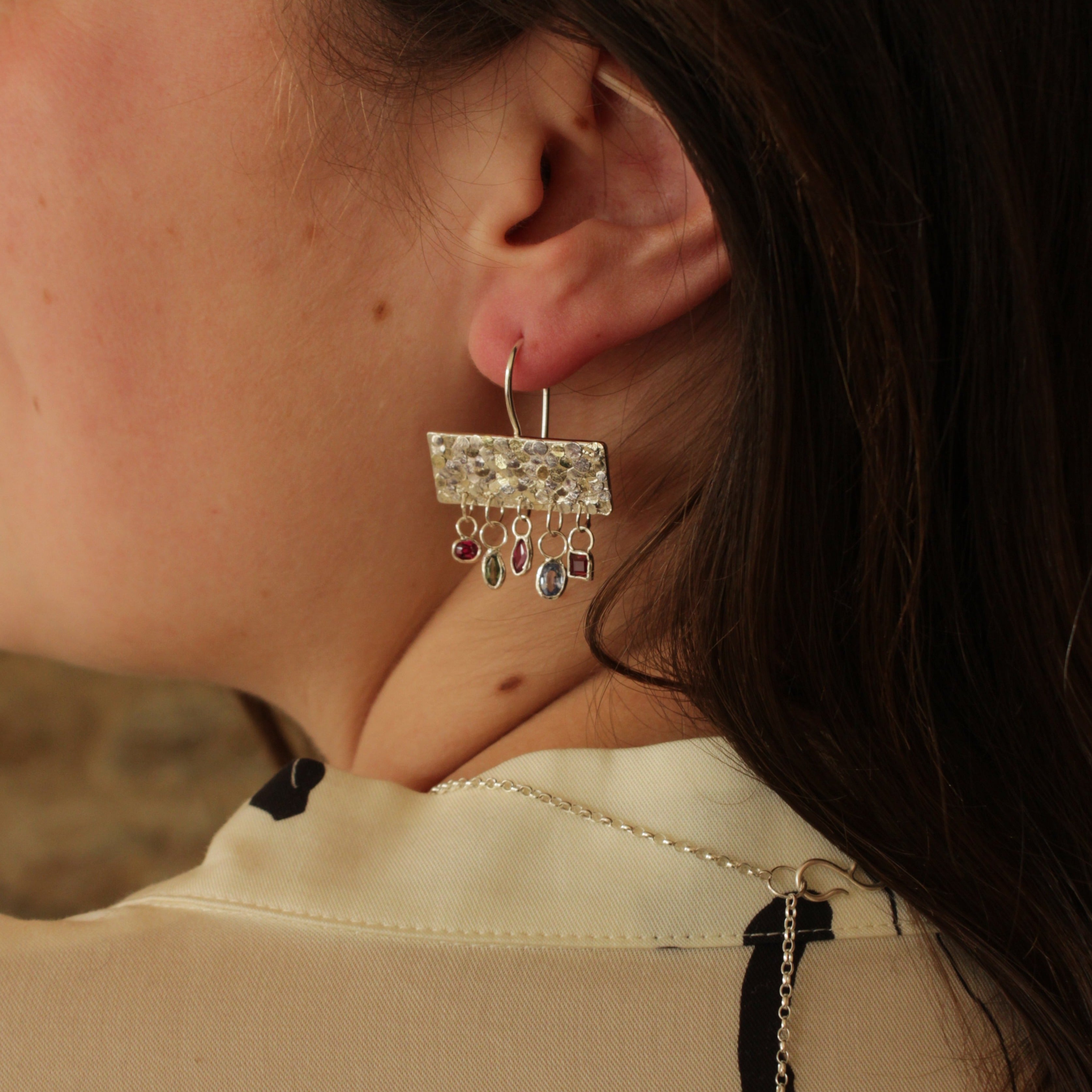 The gorgeous Calypso earrings are one of my favourite creations! They feature 10 brightly coloured natural Sapphires that hang from the bottom of the Siren plates to create a beautiful shimmer and chime. Delicate hand crafted siren details make this pair of earrings entirely unique and magical. Their otherworldly appearance is entirely one-of-a-kind and unique, hand crafted by Josie Mitchell Jewellery in her Bournemouth studio. 